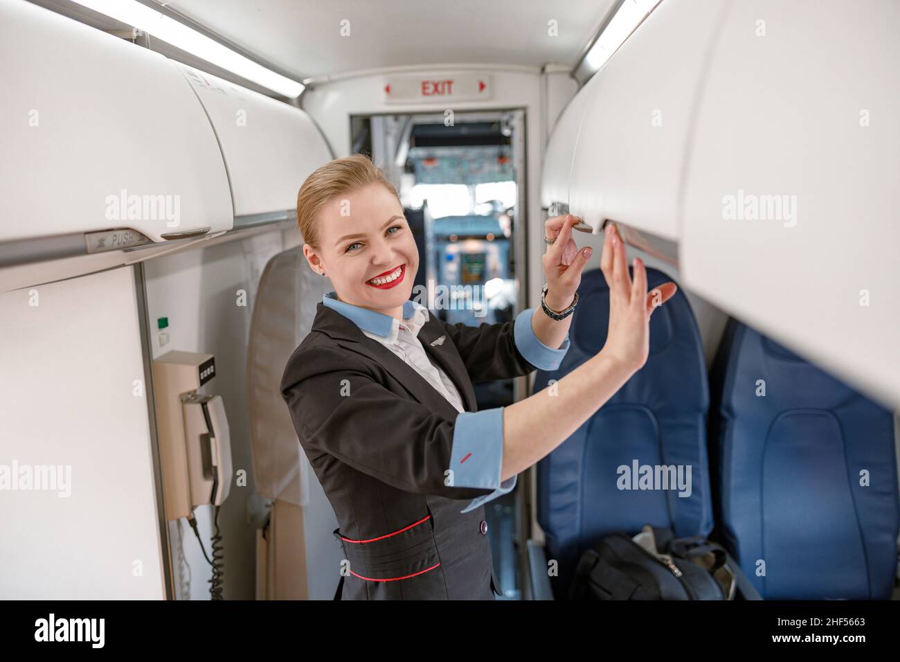 Un employé de bord joyeux qui vérifie la tablette suspendue dans l'avion  Photo Stock - Alamy