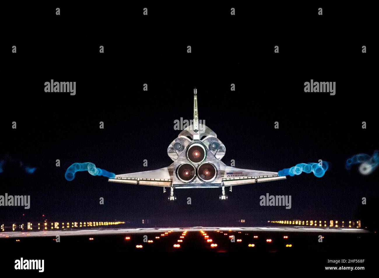 Les pistes de vapeur suivent la navette spatiale Atlantis à l'approche de la piste 15 sur le site d'atterrissage de la navette au centre spatial Kennedy de la NASA en Floride. Banque D'Images