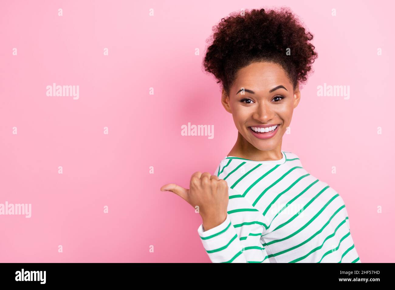 Photo de profil de mignon petit pain coiffdo jeune femme indiquer promo porter chemise blanche isolée sur fond rose Banque D'Images