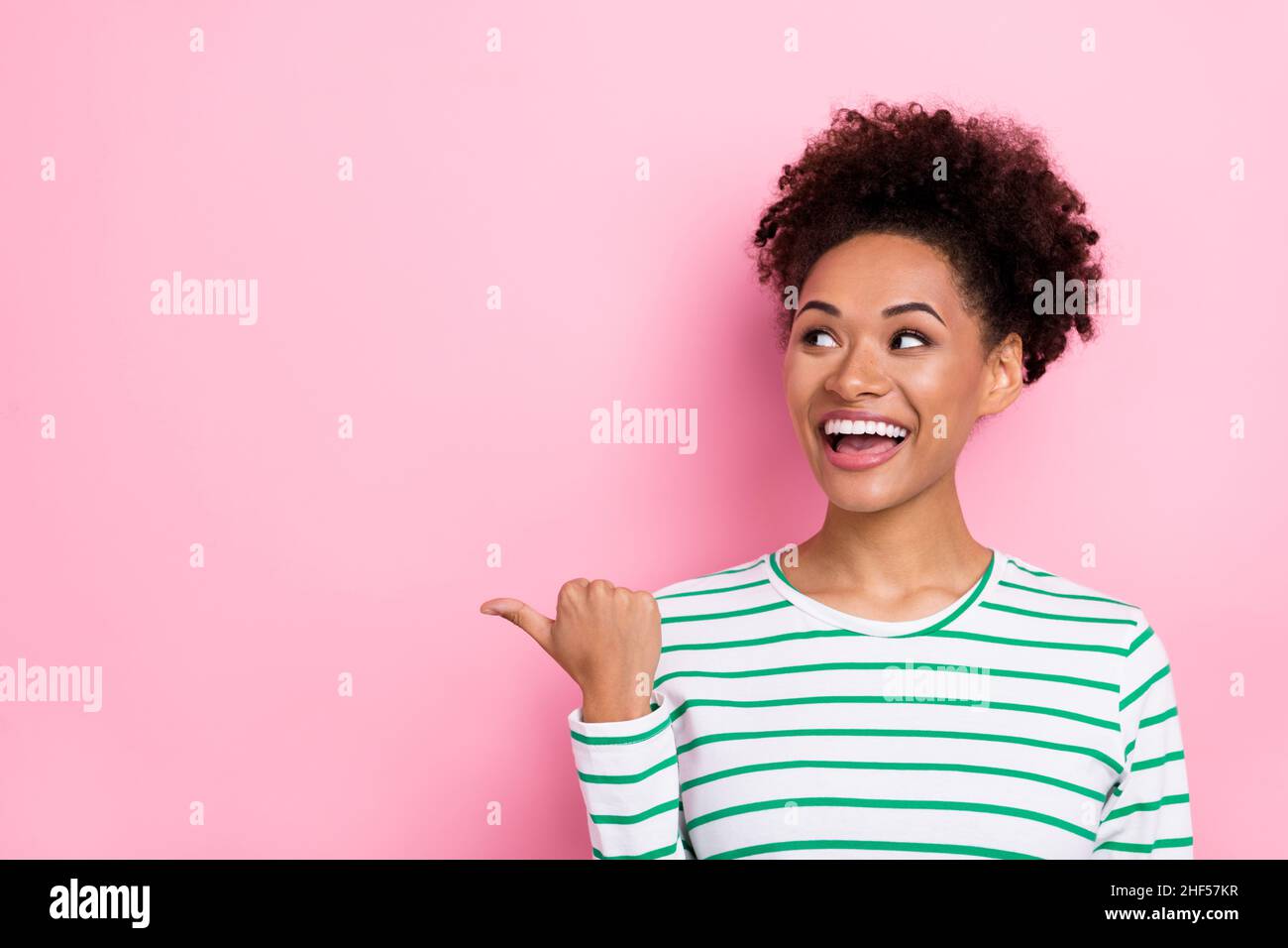 Photo de Bun Hairdo millénaires femme look promo porter chemise blanche isolée sur fond de couleur rose Banque D'Images