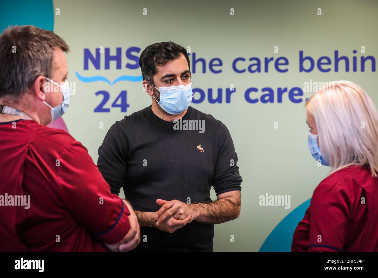 La secrétaire à la Santé, Humza Yousaf (au centre), rencontre les gestionnaires des services cliniques, Billy Togneri et Julie Lindsay, lors d'une visite au nouveau centre d'appels NHS 24 de la maison Caledonian, à Dundee.Date de la photo: Vendredi 14 janvier 2022. Banque D'Images