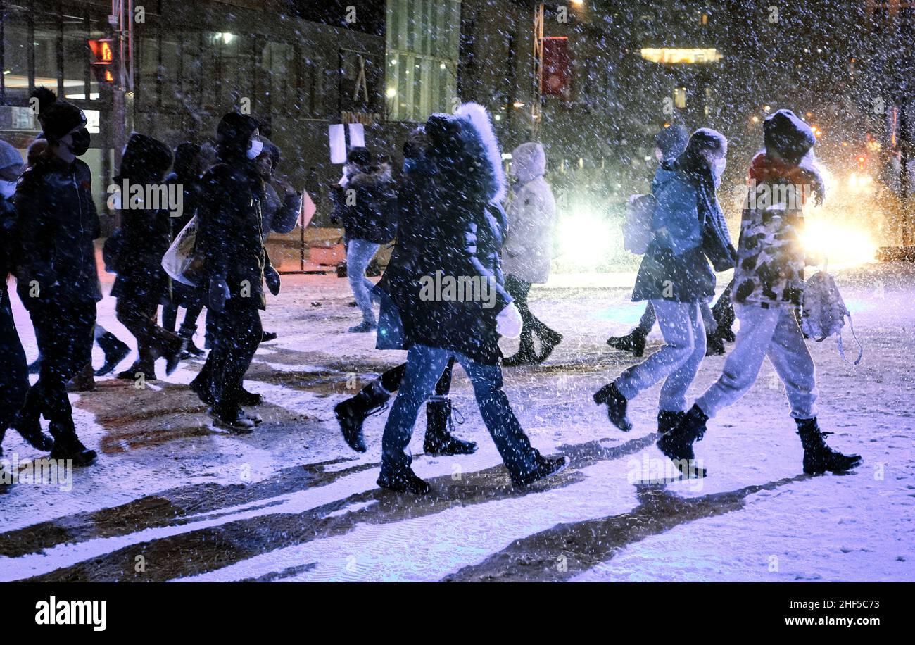 Les gens traversent la rue par une nuit froide d'hiver. Banque D'Images