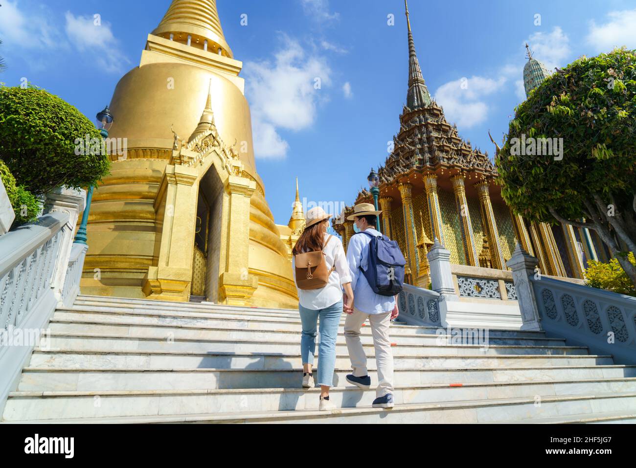 Couple asiatique touristes heureux de voyager porter un masque à protéger de Covid-19 sur eux vacances à Wat Phra Kaew Temple à Bangkok, Thaïlande Banque D'Images