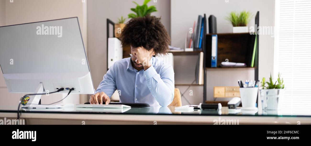 A souligné l'homme américain de l'employé d'Afrique malade à l'ordinateur Banque D'Images