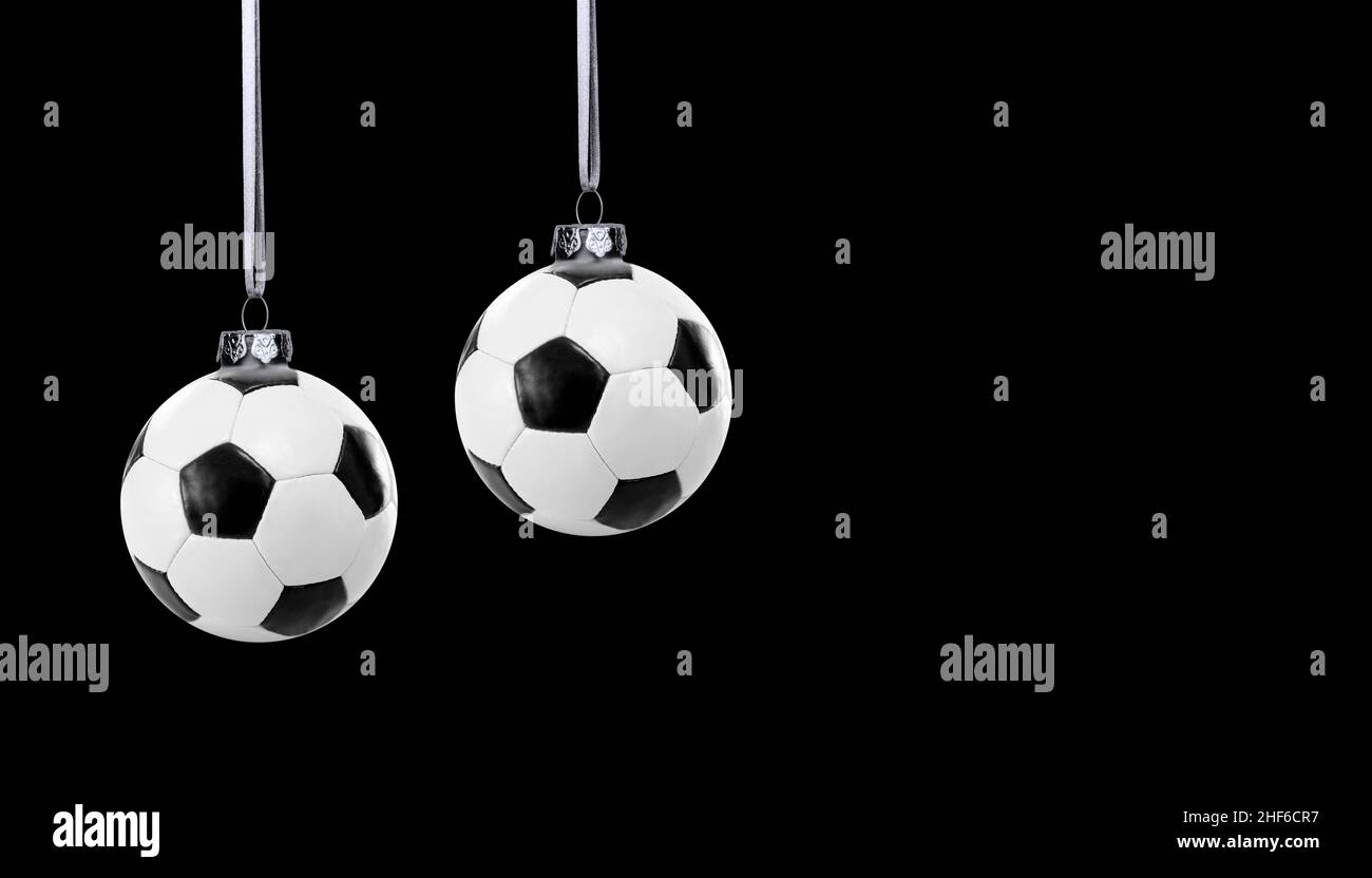 Ballons de football comme boules de Noël sur fond noir Banque D'Images