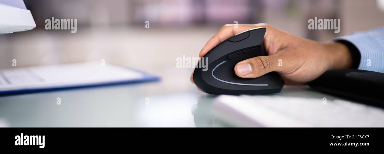 African American Man with Wrist pain Using Ergonomic vertical Mouse Banque D'Images