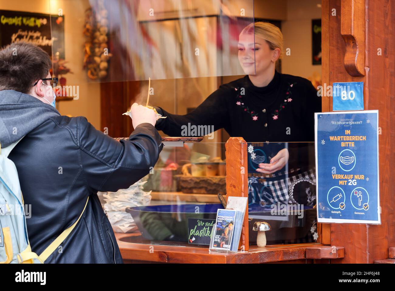 Essen, Rhénanie-du-Nord-Westphalie, Allemagne - le stand alimentaire au marché de Noël à Essen en période de pandémie de corona dans 2G conditions.Panneau d'information pour l'ordonnance de protection Corona.Vendu avec 2G seulement.Les visiteurs doivent avoir récupéré ou être vaccinés.Dans la zone piétonne d'Essen, il n'y a pas d'obligation de porter un masque, mais une recommandation de porter un masque. Banque D'Images