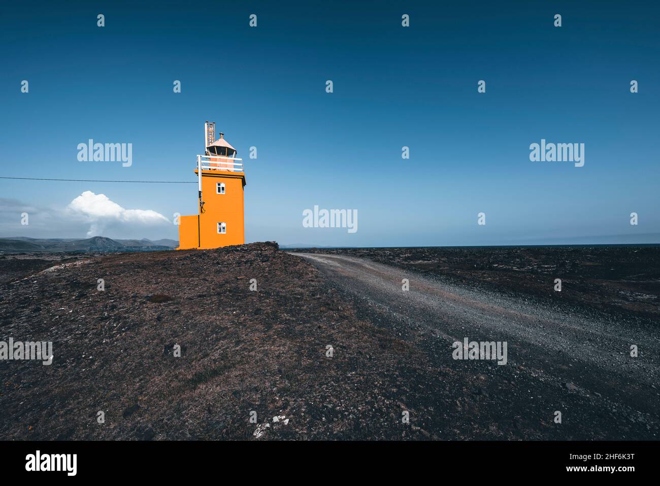 Phare avec volcan actif en arrière-plan, Hópsnesviti, Islande Banque D'Images