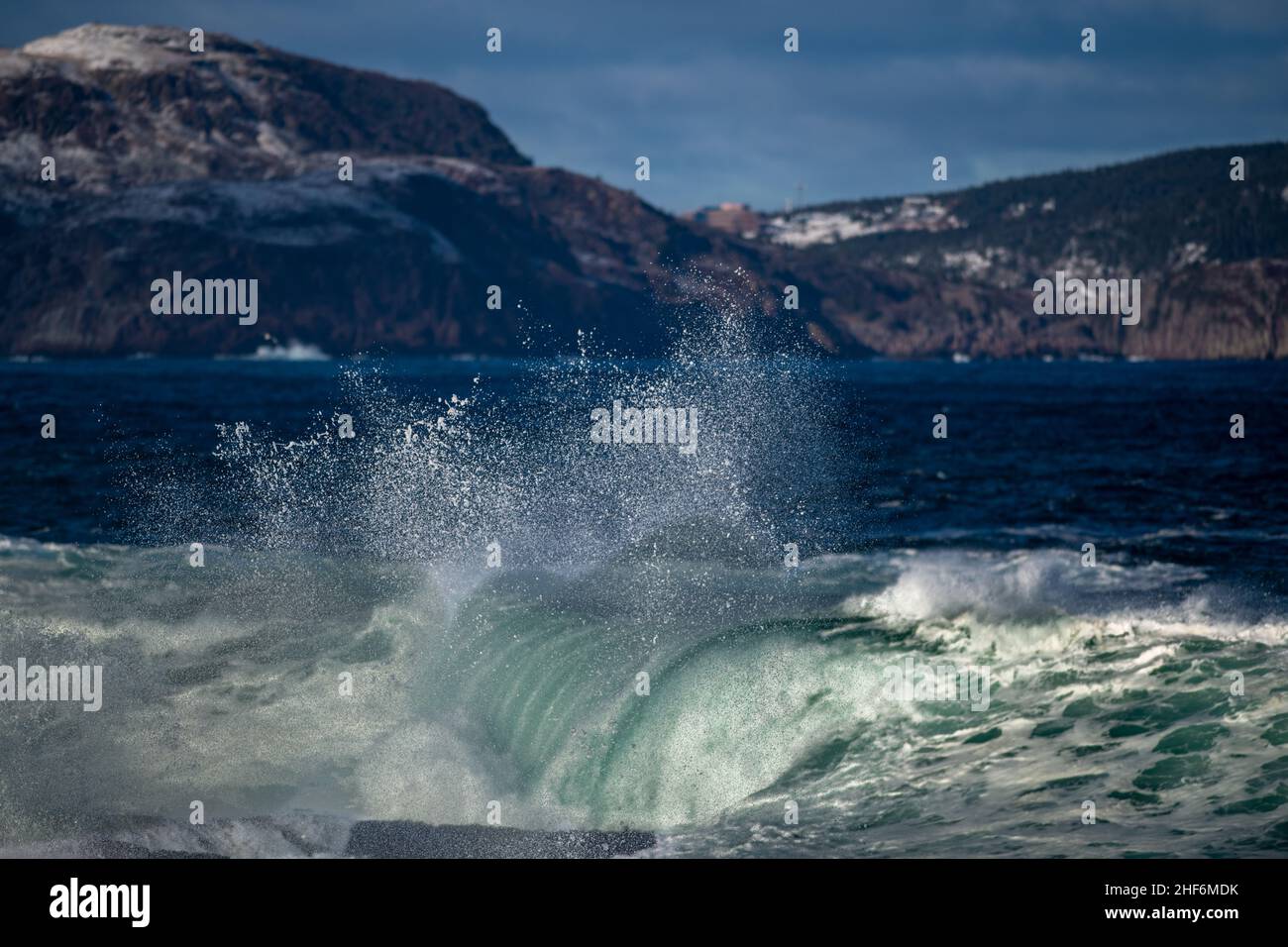 Une couleur vert turquoise en colère une boucle de rip massive d'une vague en roulant le long d'une plage.La brume blanche et la mousse de la vague sont mousseuse et moelleuse. Banque D'Images
