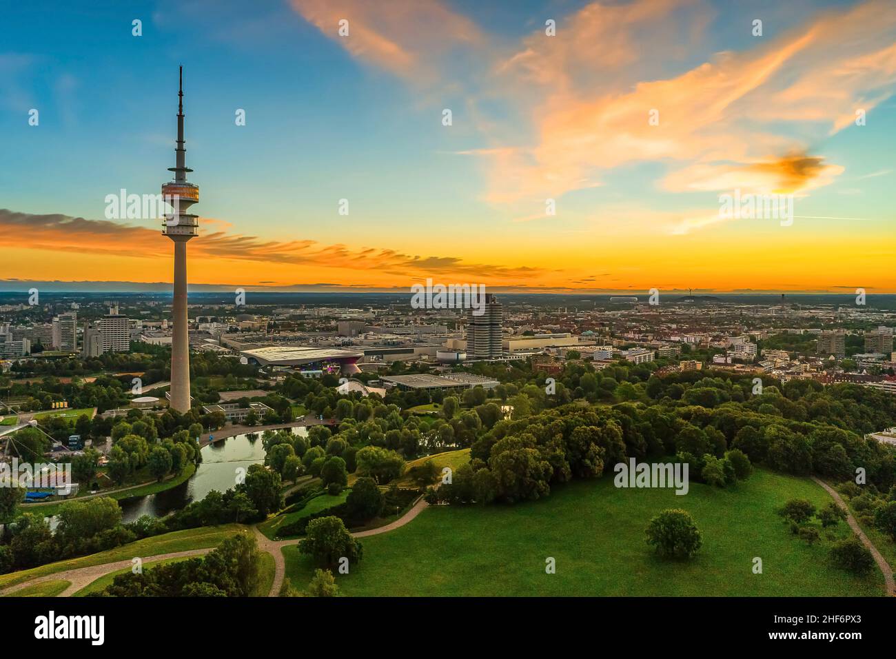 Lever du soleil d'été au-dessus de la belle ville bavaroise de Munich avec sa vue touristique populaire et épédayante sur le parc olympique avec la tour haute sous le ciel orange le matin Banque D'Images