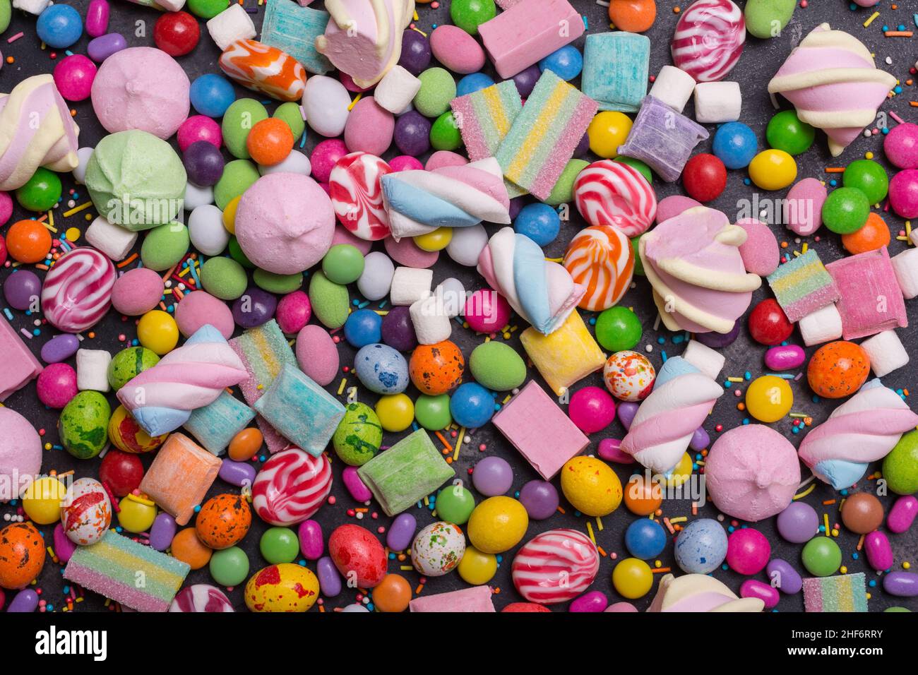 Arrière-plan de dragee doux et lumineux multicolore, bonbons, sucettes, guimauves pour une fête amusante Banque D'Images
