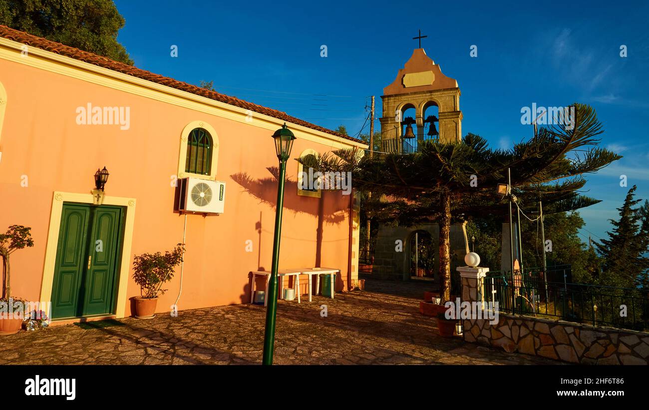 Grèce, Iles grecques, Iles Ioniennes, Corfou, côte ouest,Pentati, lumière de fin d'après-midi, rose église, bâtiment allongé, clocher,lanterne en premier plan, bleu ciel Banque D'Images