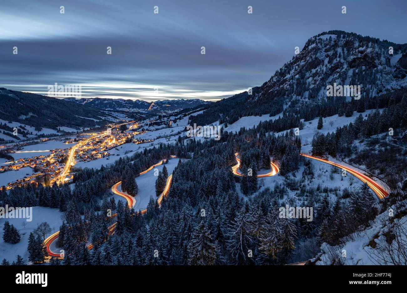 Bad Hindelang et Jochpassstrasse illuminés dans la soirée dans un paysage hivernal enneigé.Encadré par les Alpes enneigées de l'Allgäu.Bavière, Allemagne, Europe Banque D'Images
