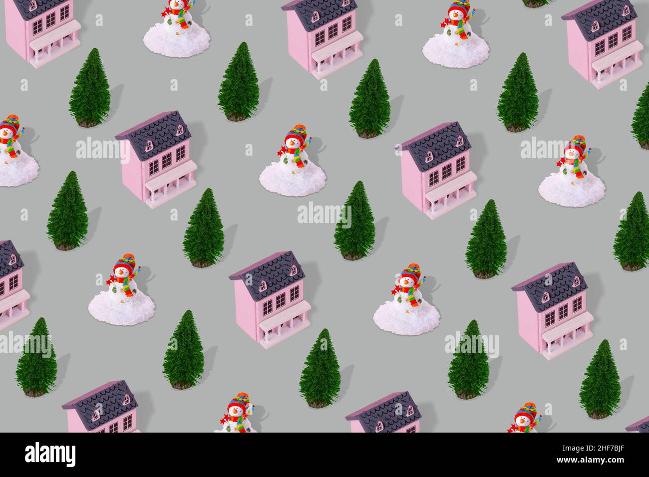 Paysage d'hiver suburbain concept de motif minimal avec maison rose, arbre de Noël et bonhomme de neige sur fond gris.Immobilier résidentiel, soutient Banque D'Images