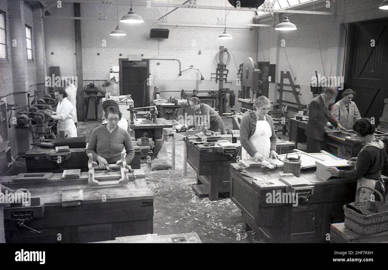 1936, historique, Mesdames à un cours de travail du bois, les montrant à des bancs de travail et un instructeur masculin aidant l'un d'eux, South East Essex Technical College Essex, Angleterre, Royaume-Uni. Banque D'Images