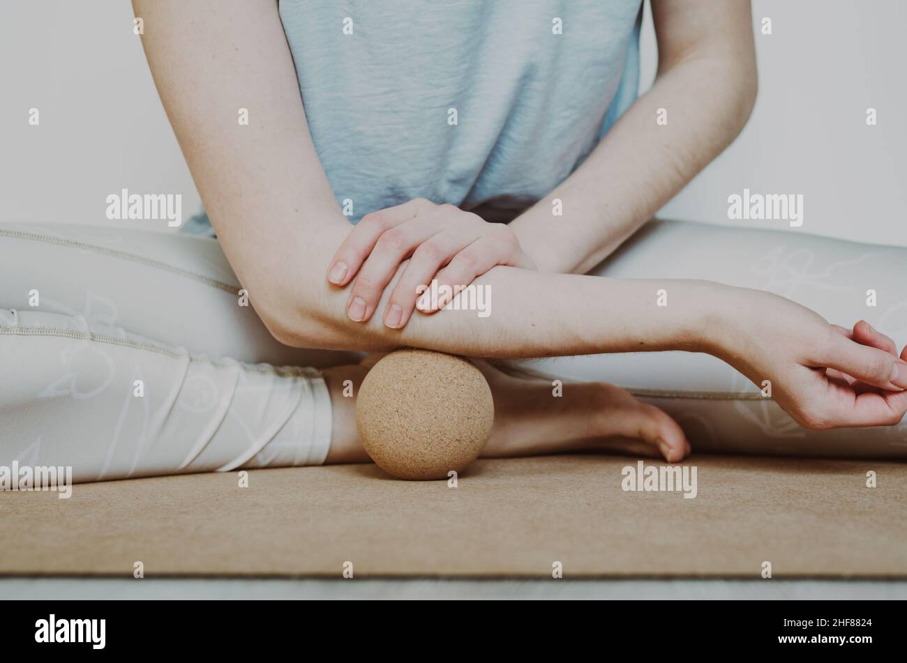 Muscles de l'avant-bras relâchement myofascial avec grande bille de massage en liège sur le tapis de yoga en liège. Concept : pratiques d'autosoins à domicile Banque D'Images