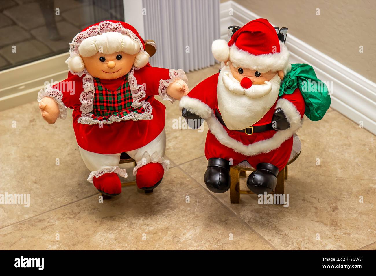 Miniature M. & Mme Santa Claus assis sur des mini-chaises Banque D'Images