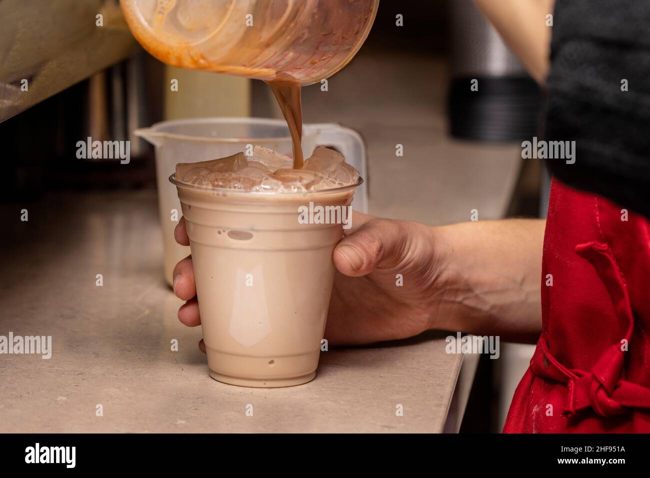 Un barista de la maison de café prépare une boisson glacée pour un client Banque D'Images