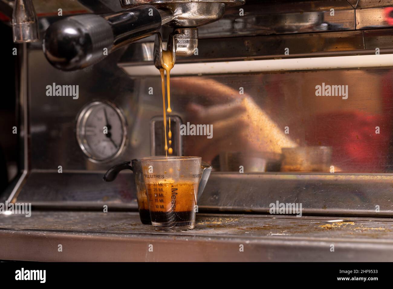 Des doses de café sont versées à une machine à expresso dans un café Banque D'Images