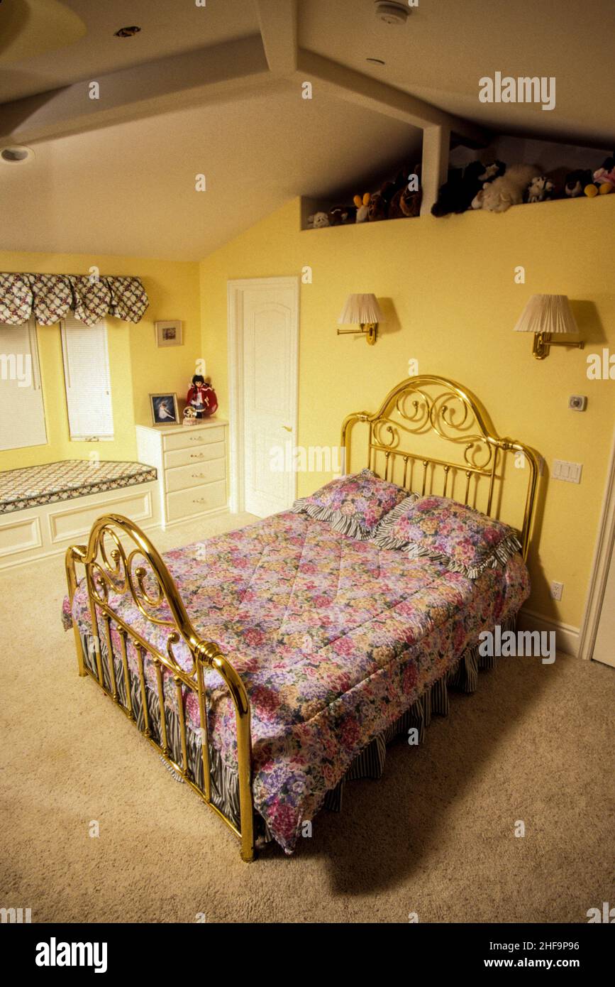 La chambre d'une jeune fille à Laguna Niguel, CA, comprend un lit en laiton et une collection d'animaux en peluche. Banque D'Images