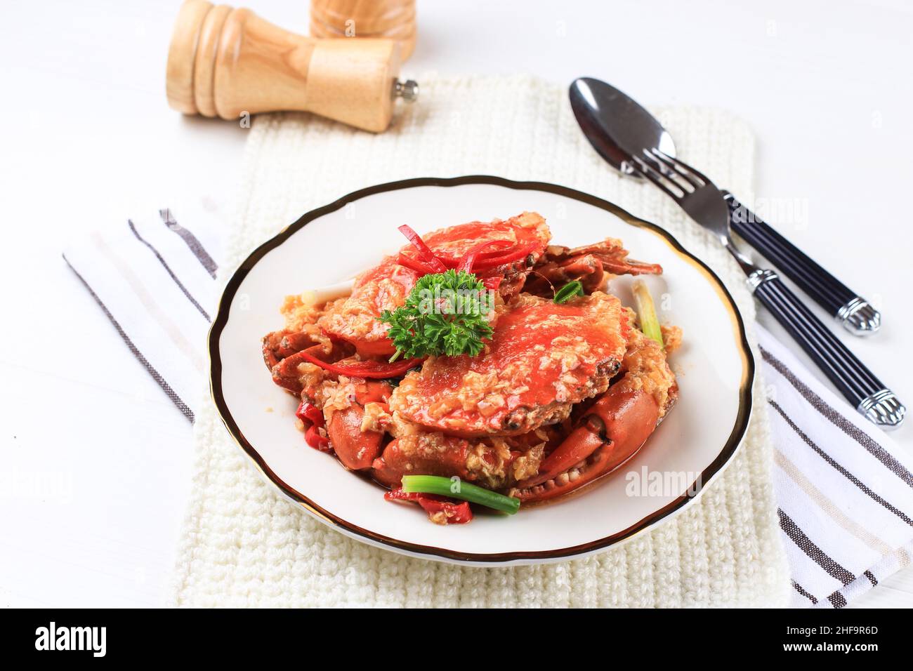 Crabe de boue de Chili, crabe avec sauce Singapourienne, cuisine spéciale de Singapour.Servi sur une assiette blanche Banque D'Images