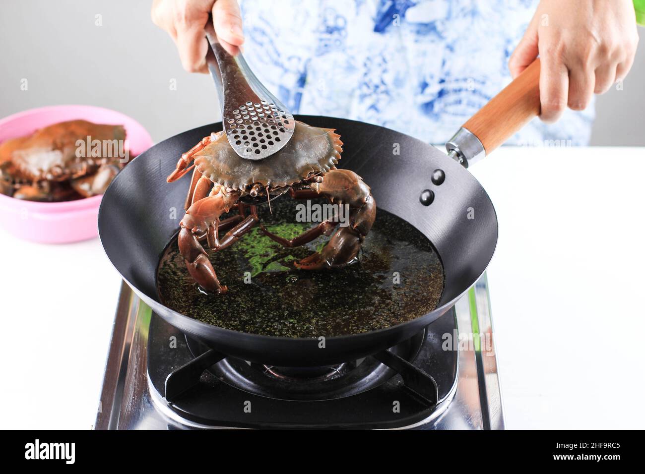 Accueil processus de cuisson faire du crabe de Chili Mud, du crabe frit à l'huile chaude sur le wok noir Banque D'Images