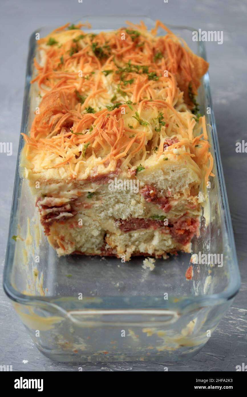 Plat de cuisson Focus Inside sélectionné, pain salé maison Pudding avec saucisse et fromage cheddar râpé, servi sur un plat de cuisson transparent Banque D'Images