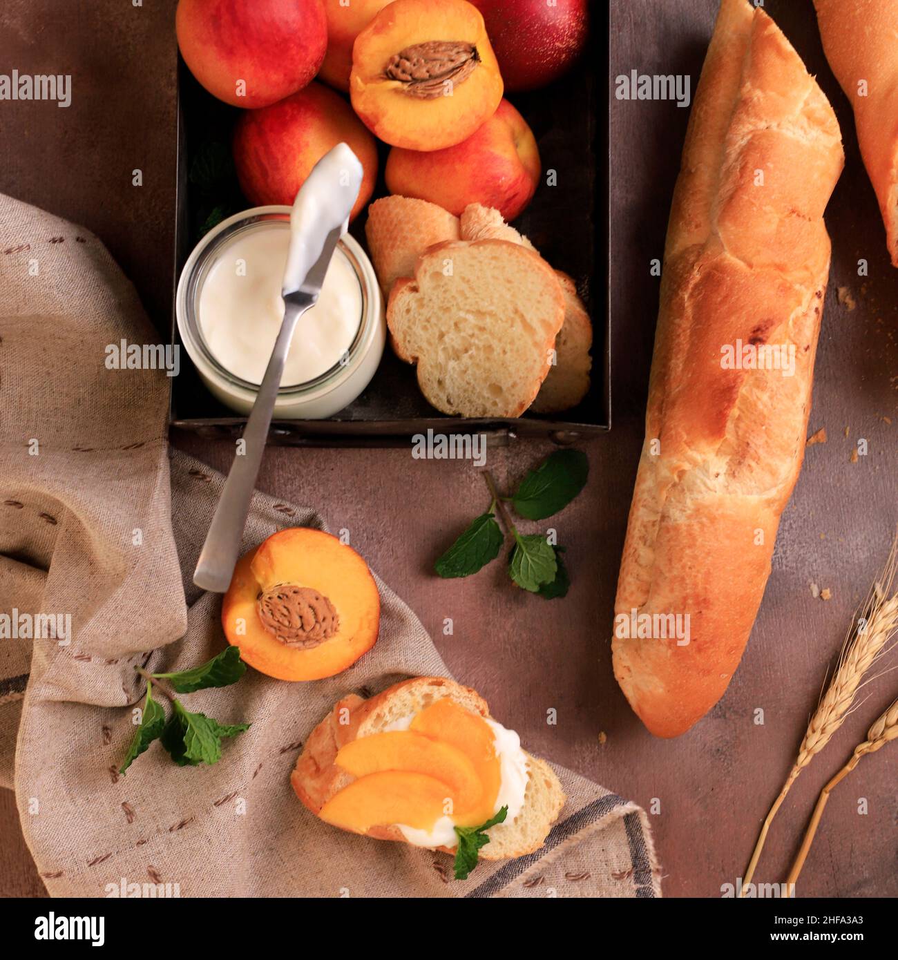 Coupez la baguette en tranches avec du yogourt et de la nectarine/pêche en tranches.Vue de dessus sur un arrière-plan rustique Banque D'Images