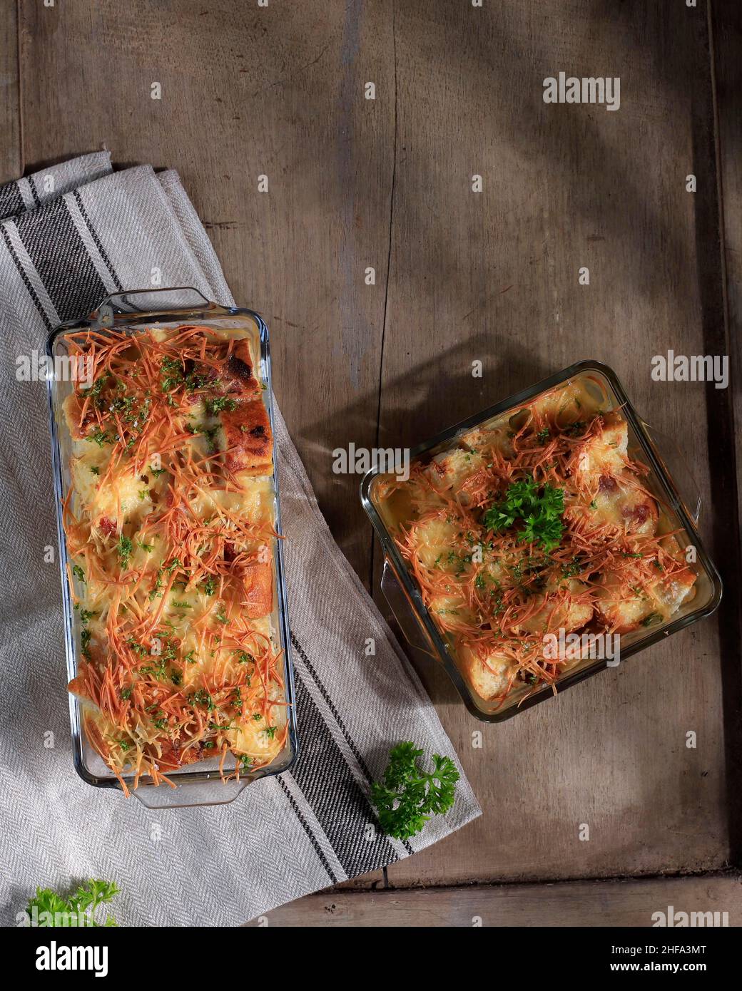 Top View pain savoureux maison Pudding avec saucisse et fromage cheddar râpé, servi sur un plat de cuisson transparent Banque D'Images