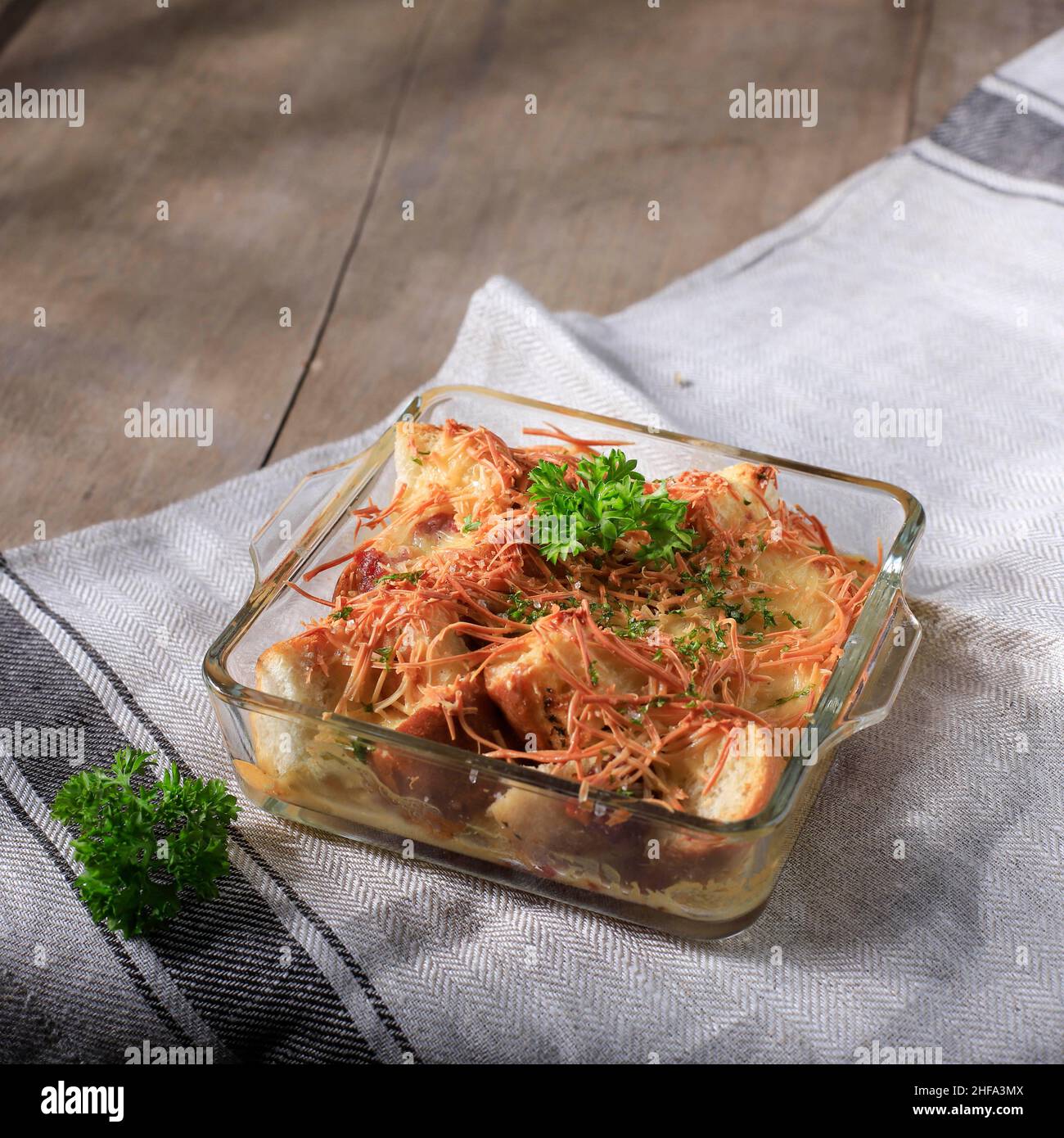 Sélection de pains maison Focus Pudding avec saucisse et fromage cheddar râpé, servi sur un plat de cuisson transparent Banque D'Images