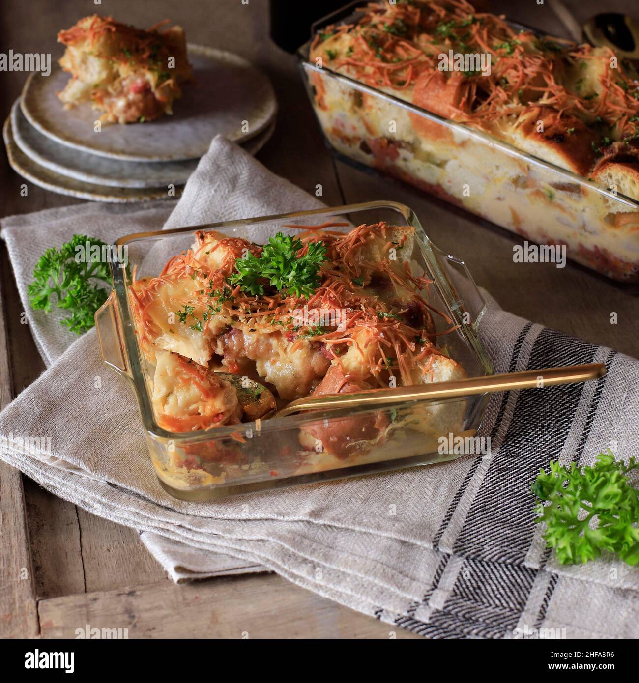 Sélection de pains maison Focus Pudding avec saucisse et fromage cheddar râpé, servi sur un plat de cuisson transparent Banque D'Images