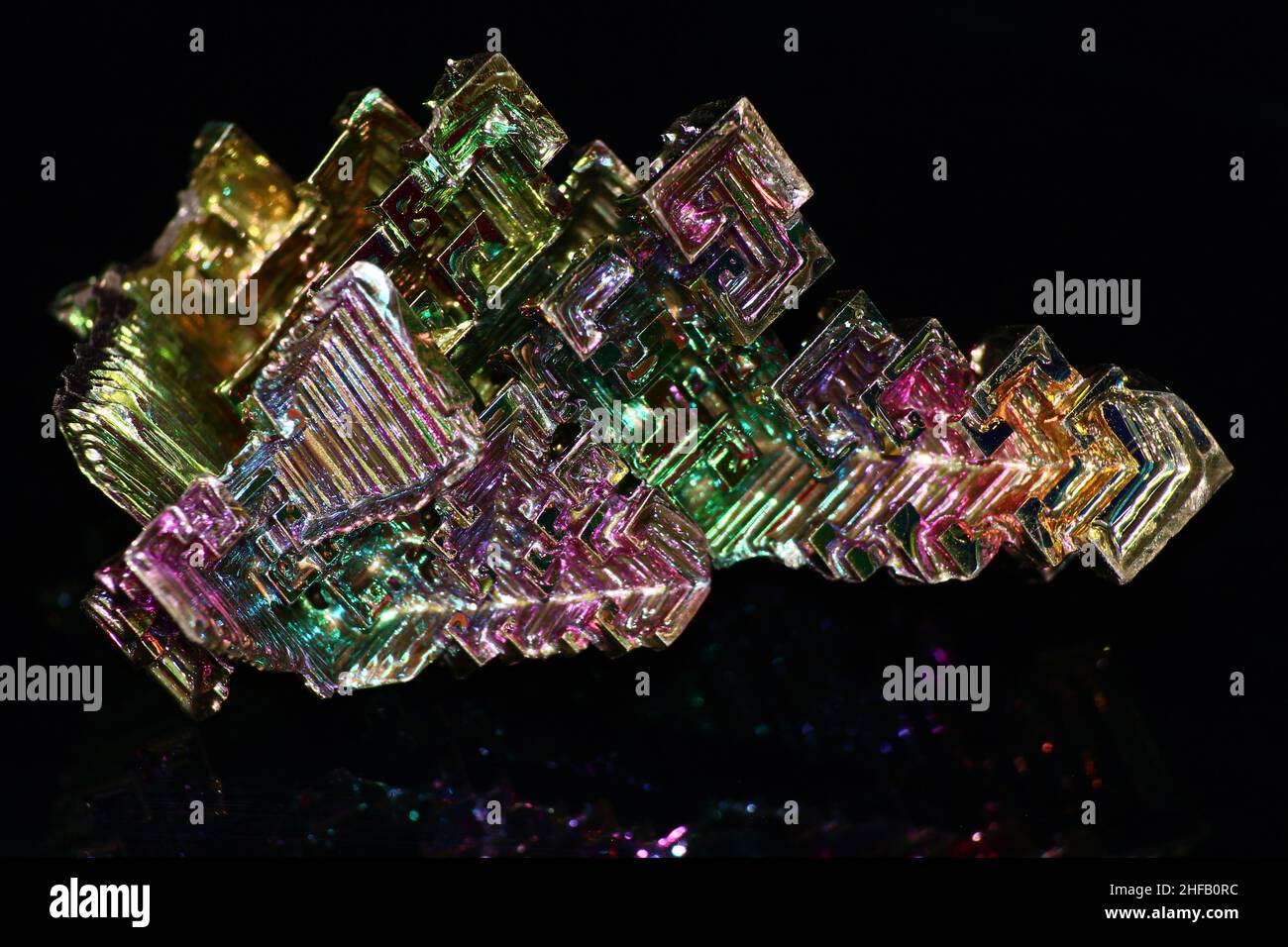 Cristal de bismuth synthétique Bismuthum avec film d'oxyde irisé sur fond noir Banque D'Images