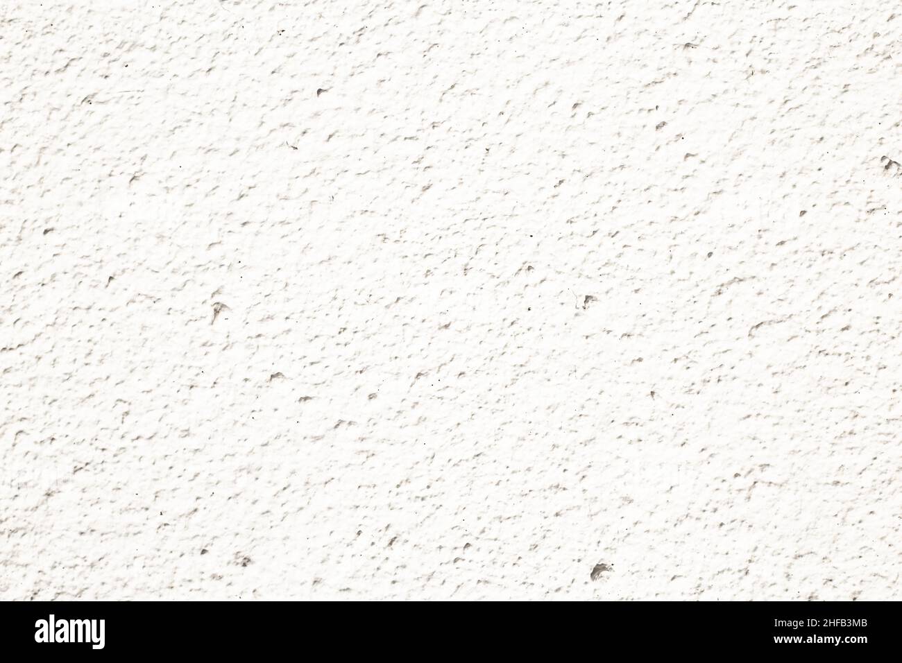 Un mur blanc en béton façade grossière faite de ciment naturel avec des trous et des imperfections séparant les couches comme un arrière rustique vide froid stérile texture Banque D'Images