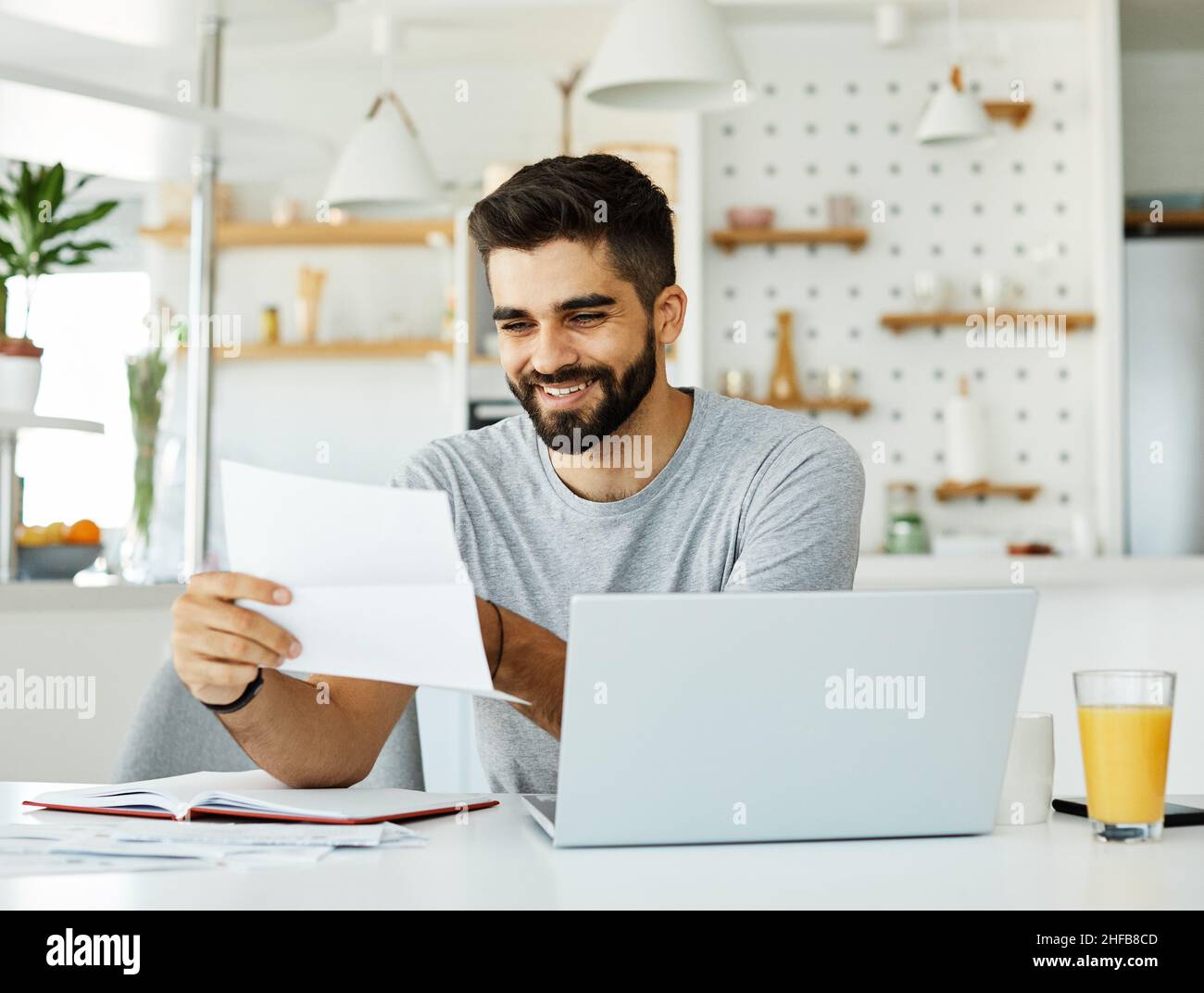 ordinateur portable homme ordinateur à la maison technologie jeune étudiant entreprise internet étude document de la lecture de la paperasse Banque D'Images