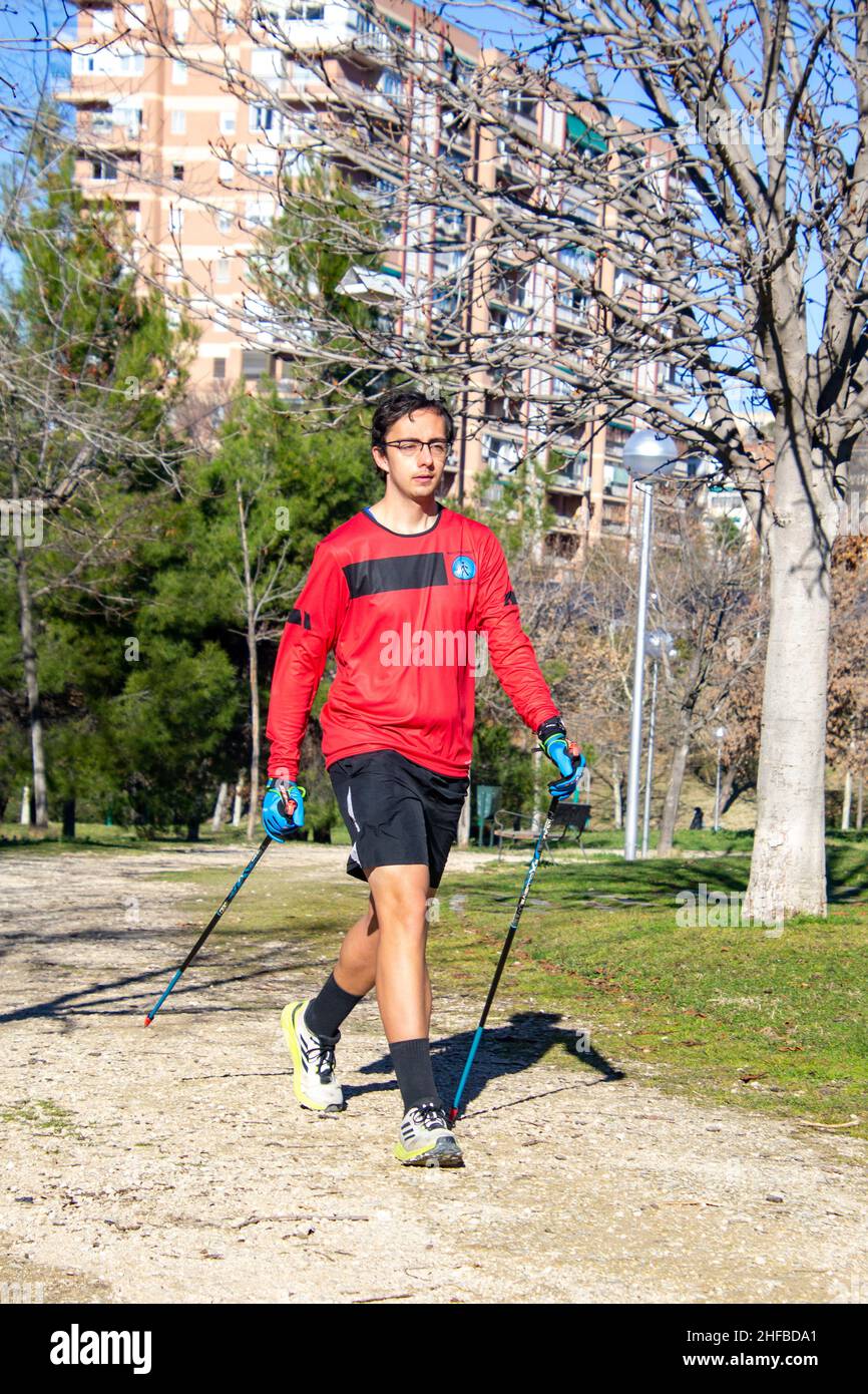 Marche nordique.Jeune pratiquant le sport marche nordique avec des bâtons dans un parc en plein air à Madrid, en Espagne.Europe.Photographie. Banque D'Images