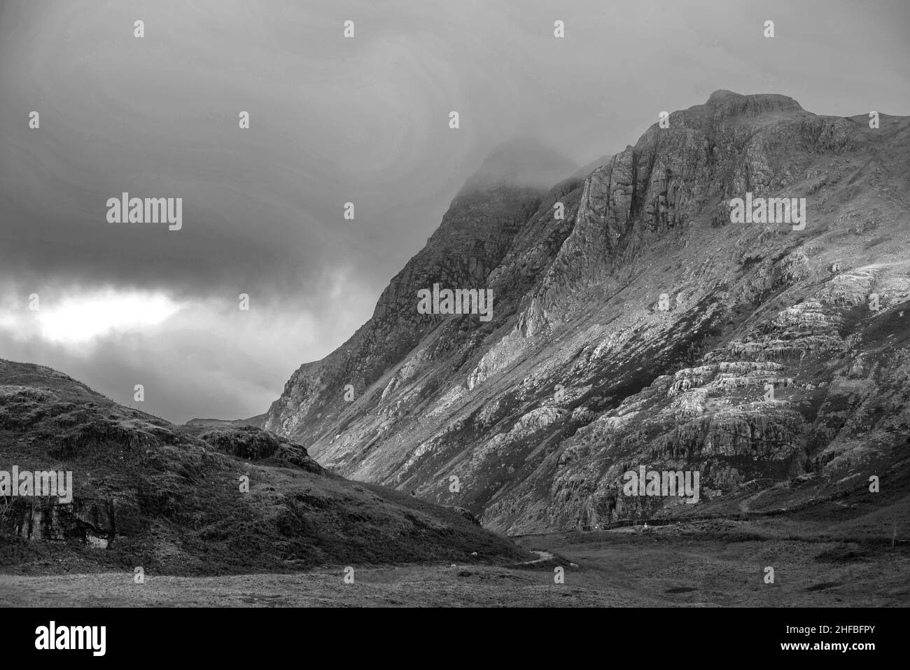 Noir et blanc paysage épique de lumière de lever de soleil sur Blea Tarn dans le Lake District avec une lumière étonnante sur les montagnes lointaines Banque D'Images