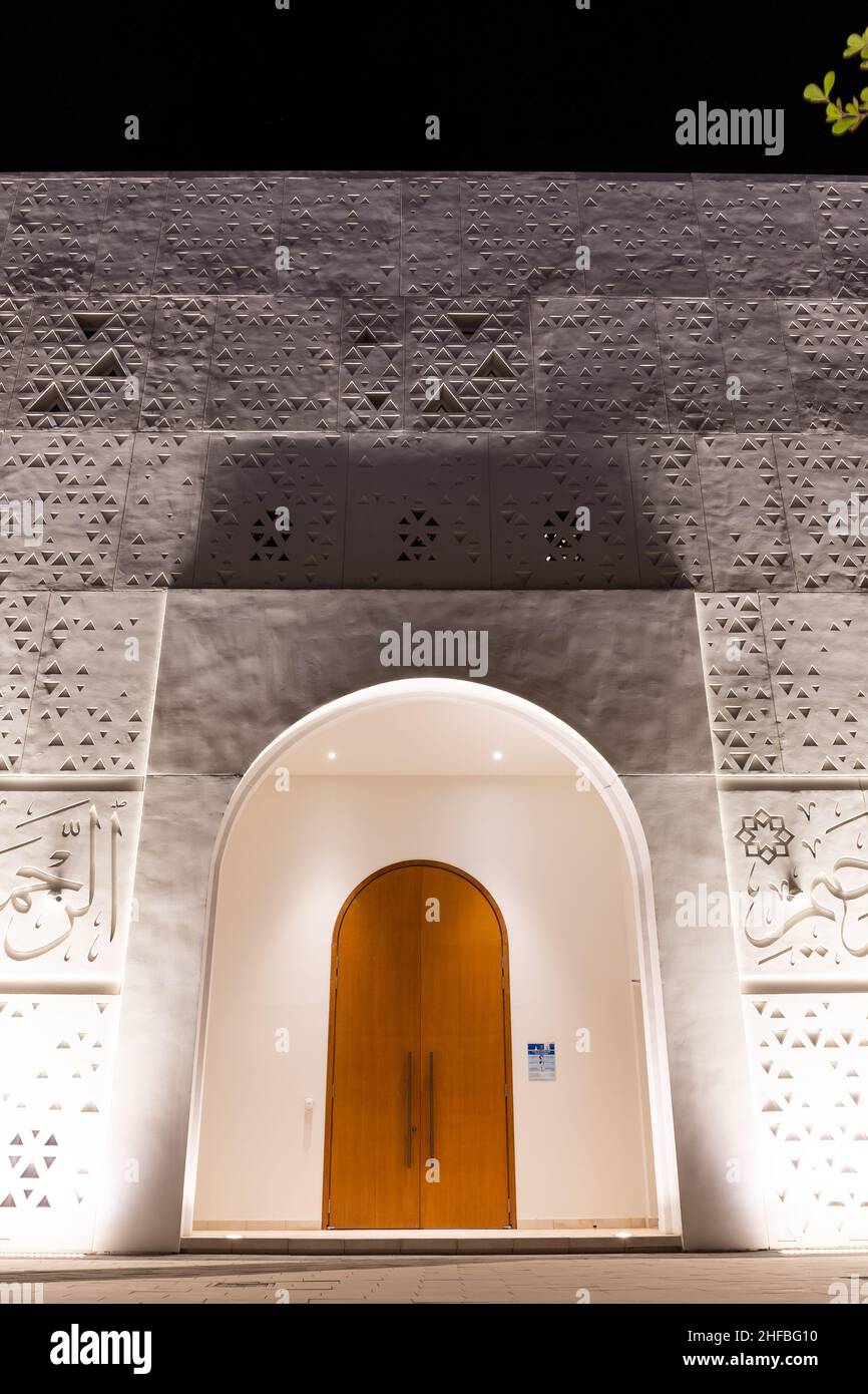 Dubaï, Émirats arabes Unis, 24.09.2021.Portes d'entrée éclairées et façade de la Mosquée blanche de la lumière à Dubaï, avec versets Quran et motifs géométriques triangulaires. Banque D'Images