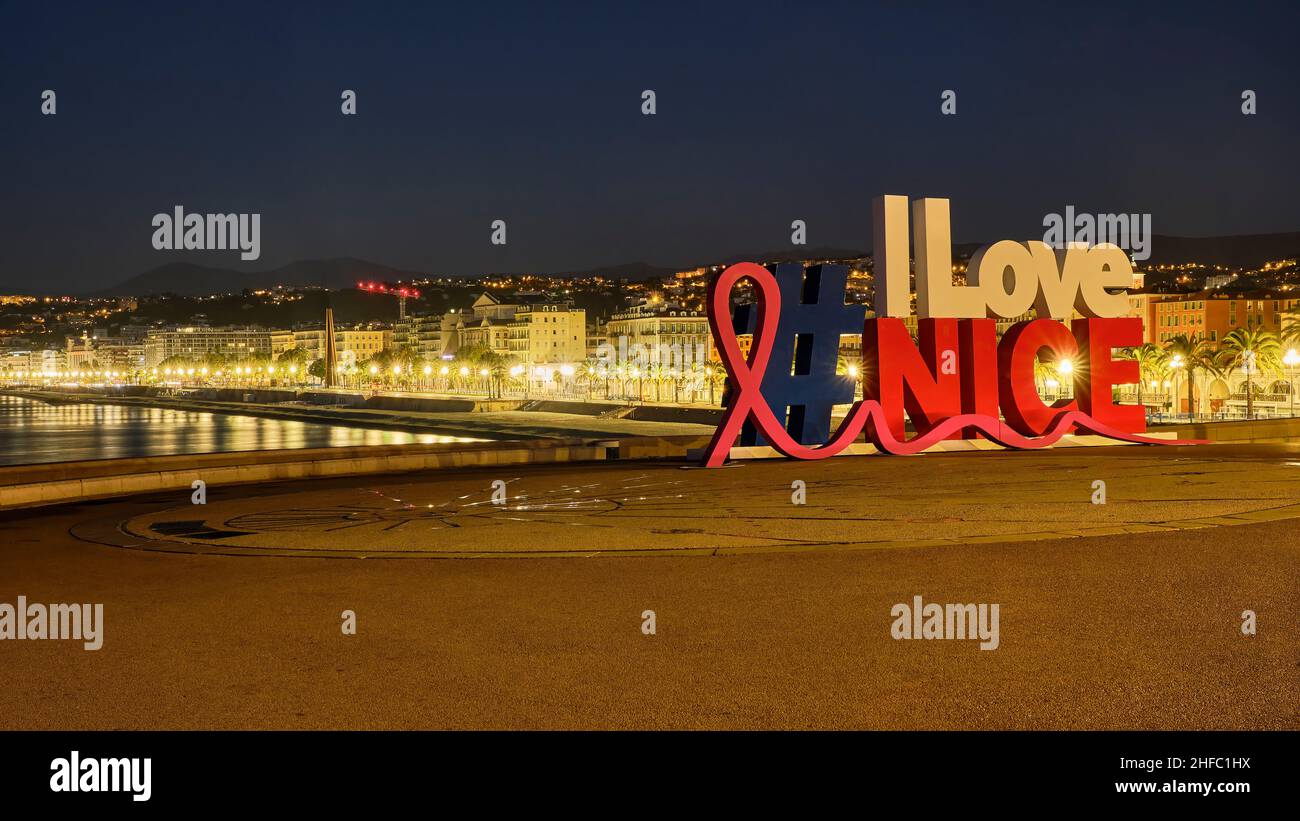 Le panneau coloré I Love Nice la nuit avec la toile de fond de la Promenade des Anglais le long de la Côte d'azur France. Banque D'Images