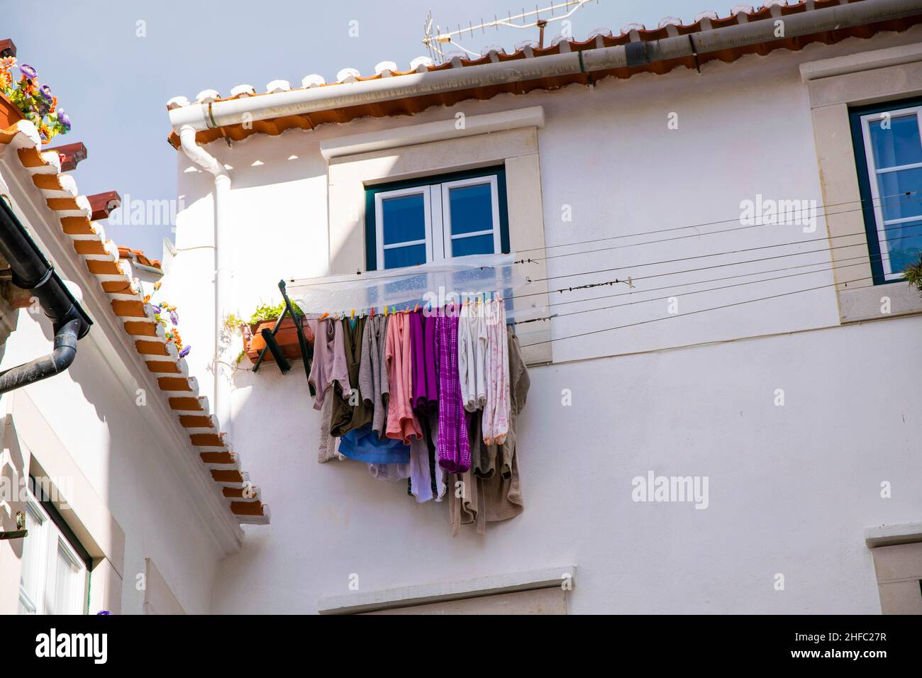 Beaucoup de vêtements suspendus de balcons dans les rues étroites du quartier d'Alfama, Lisbonne, Portugal.Mode de vie simple traditionnel typique dans l'ancien Banque D'Images