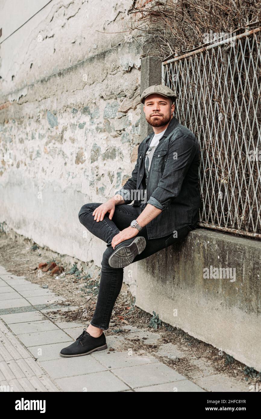 Portrait d'un beau gars avec un chapeau de lierre appuyé sur le mur Banque D'Images