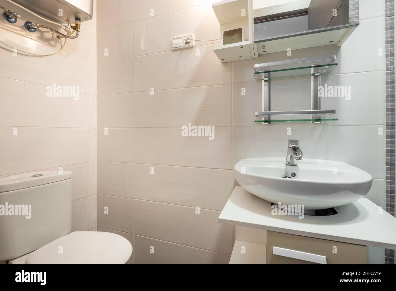 Petite salle de bains avec lavabo en porcelaine et toilettes Banque D'Images