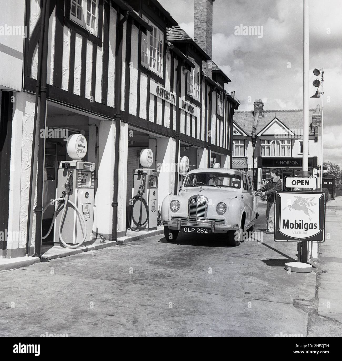 1950s, historique, une voiture britannique Austin de l'époque qui obtient de l'essence à Osterley Motors, un garage et une station-service à Osterley sur la Great West Rd, Londres, Angleterre, Royaume-Uni. Banque D'Images