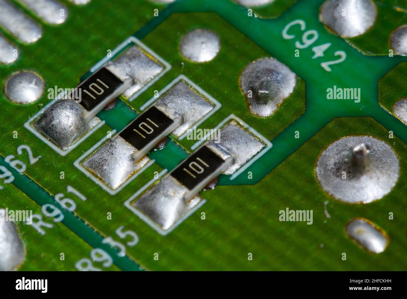 Plusieurs résistances CMS soudées sur une carte de circuit imprimé (PCB) verte. Banque D'Images