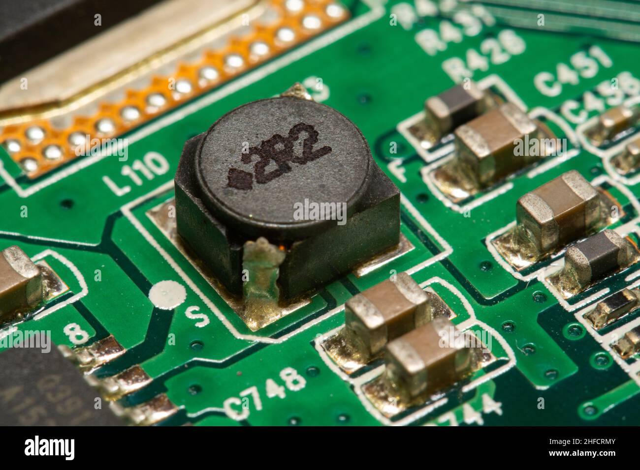 Inductance CMS et autres composants électroniques soudés sur une carte de circuit imprimé (PCB) verte. Banque D'Images