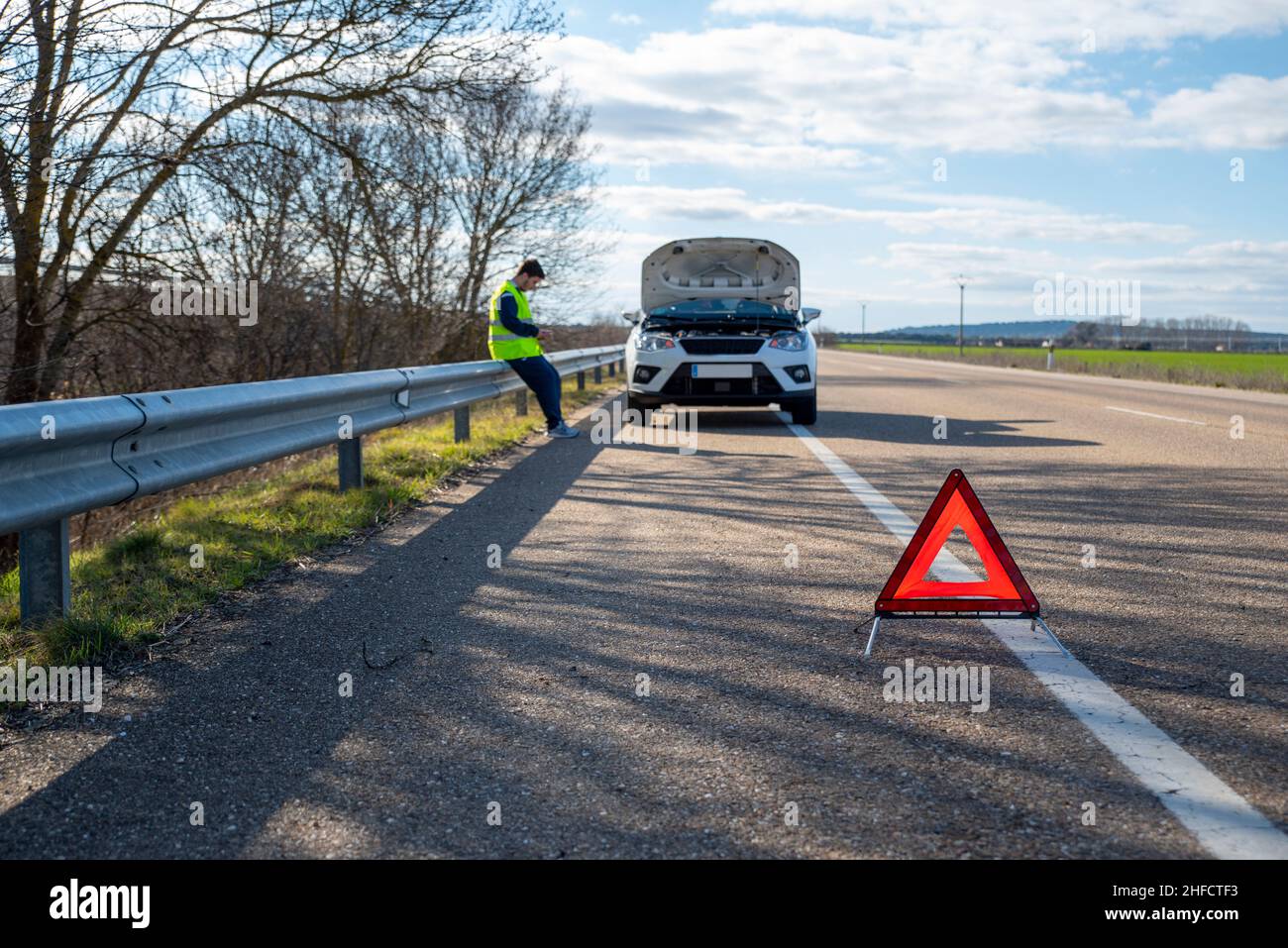 Le triangle rouge avertit d'un véhicule en panne arrêté sur l'épaule de la route Banque D'Images