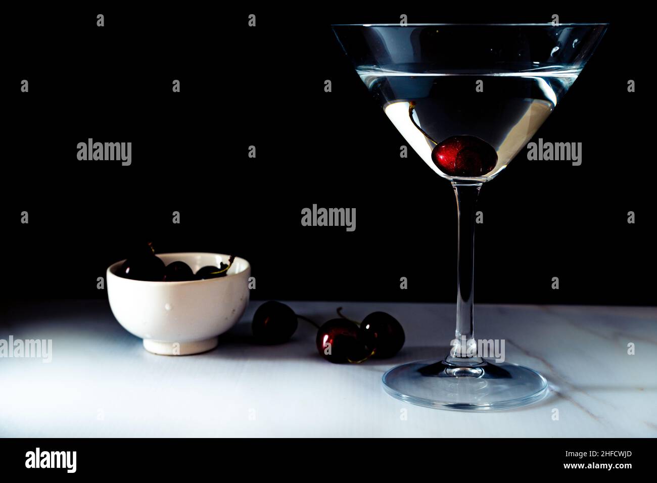 Un verre à Martini avec une cerise.Arrière-plan noir, espace de copie important Banque D'Images
