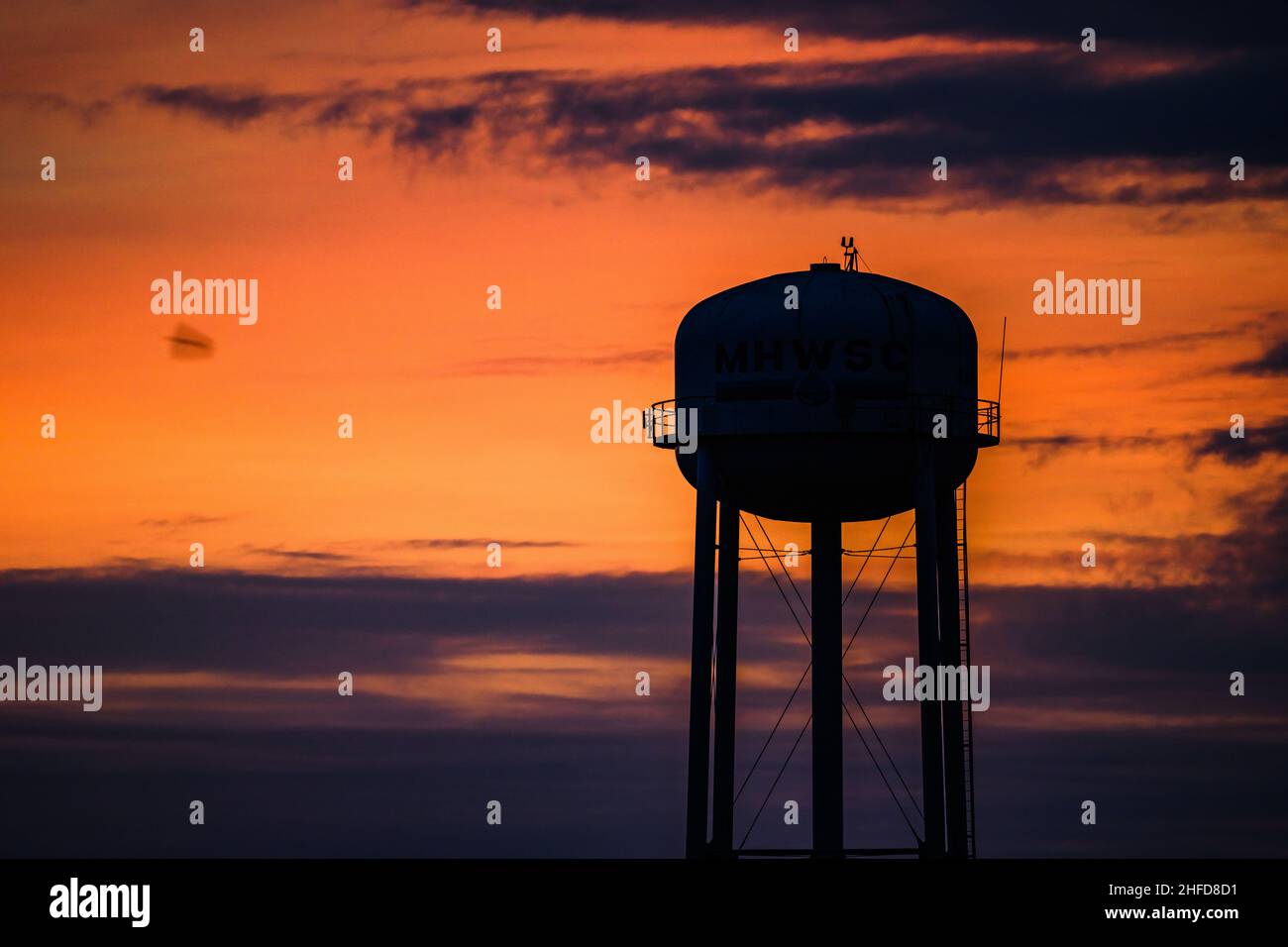 Silhouette d'une tour d'eau avec fond de ciel coloré.McAllen, Texas, États-Unis. Banque D'Images