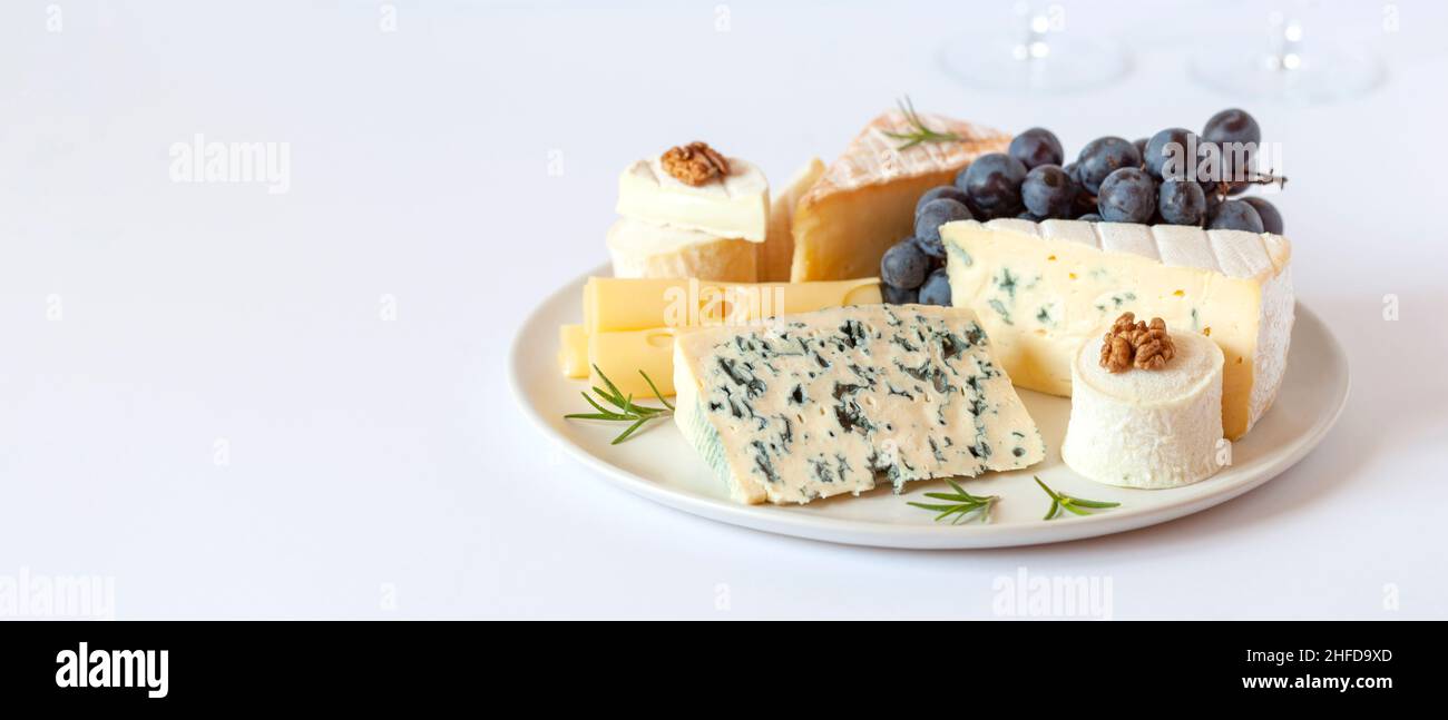 Assiette de fromage servie avec des raisins et des noix, espace de copie Banque D'Images