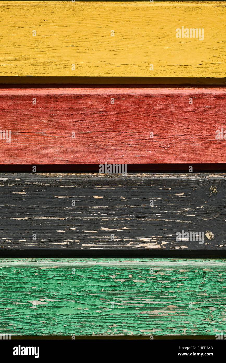 Arrière-plan de planches rugueuses multicolores, jaune, rouge, noir et vert.Peinture écaillée texture du bois avec de vieilles couleurs décolorées.Murs rustiques à motifs en bois. Banque D'Images