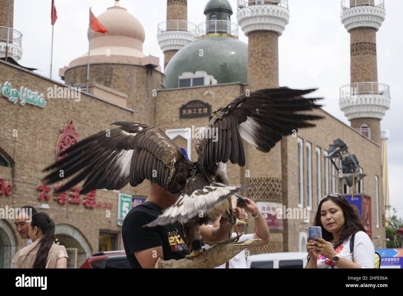 Touriste Prenez photo d'un faucon sur la place d'un bazar traditionnel à Urumqi Banque D'Images